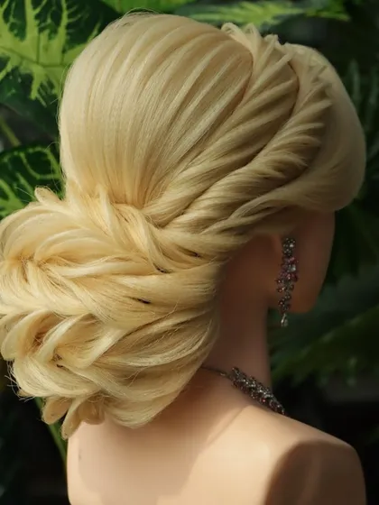 A beautiful reception bun hairstyle. The lower part of the bun is crafted with intricate leaf-like layers, creating a highly textured and visually interesting look.