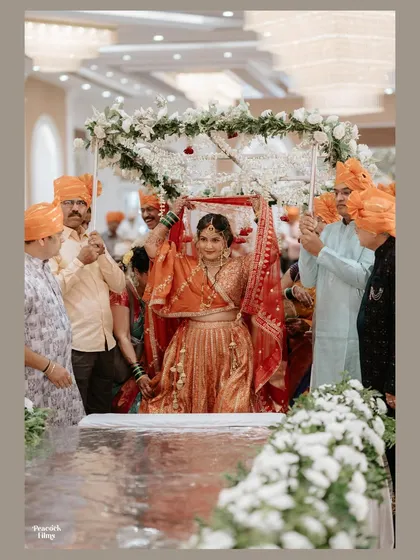 The bride's grand entrance under a beautiful floral canopy (phoolon ki chadar), a traditional and emotional moment as she walks towards her future.