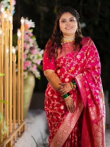 A full-length view of the bride's reception look. The rich pink saree is balanced with soft glam makeup and a relaxed hairstyle.