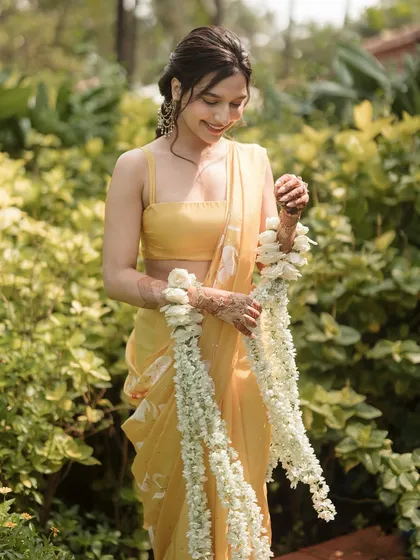 A close-up of the bride with her floral kaleeras, showing the delicate details of the flowers.