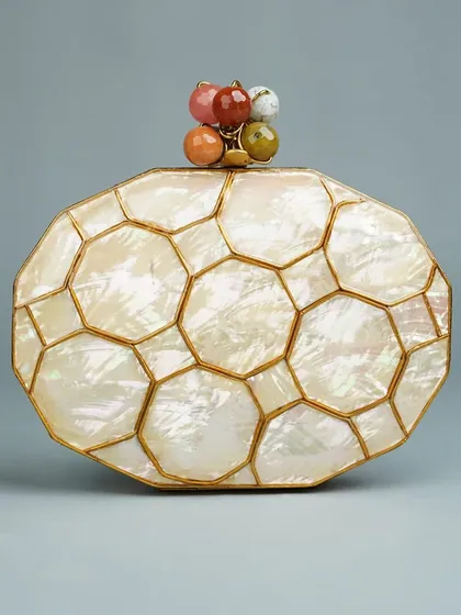 This clutch features a beautiful honeycomb pattern crafted from mother of pearl, set in a brass frame. The clasp is a delightful cluster of colorful polished stones, adding a unique and artistic touch.