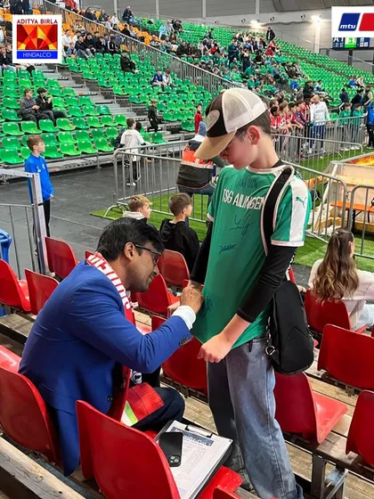The next generation of fans. Mr. Gupta signs an autograph for a young German fan at the MTU Cup, showing the global appeal and friendships forged through football.