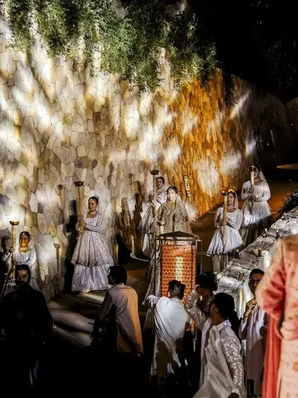 A dramatic shot of the groom's welcome, with dancers and theatrical lighting creating a grand spectacle.