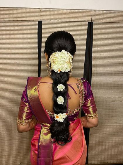 A beautiful messy braid for an engagement, styled with a jasmine gajra and smaller flowers tucked into the plait for a delicate finish.