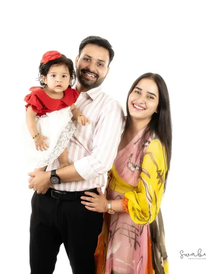 A bright and happy family portrait. Their coordinated outfits and big smiles make for a picture-perfect memory.