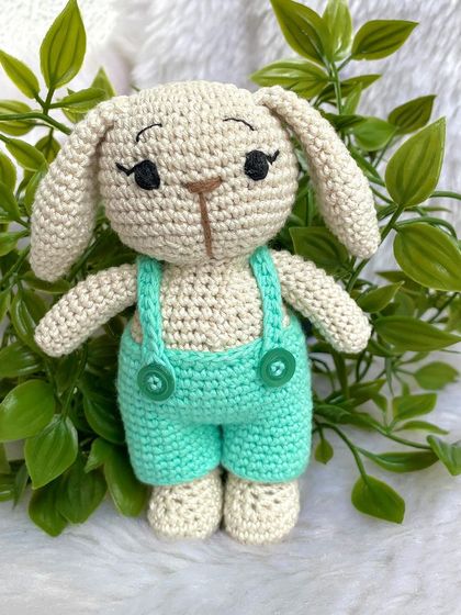 This handsome boy bunny wears a cute pair of sea-green dungarees. His long eyelashes give him such a sweet and gentle expression.