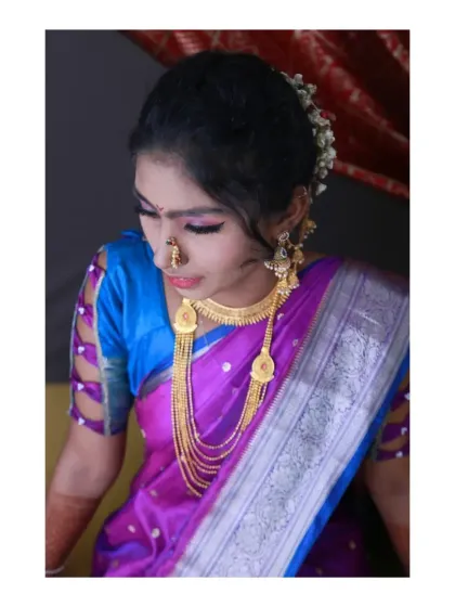 A detailed shot focusing on the bride's makeup, jewelry, and the unique sleeve design of her blouse. Capturing these elements is key in traditional portrait photography, as they each tell a part of the story.