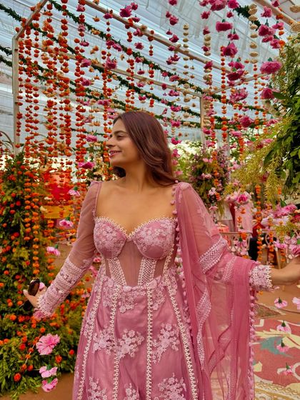 Surrounded by flowers in my beautiful pink Anarkali. This outfit proves you can have structure and flow in one piece, making it a great choice for weddings and festive occasions.