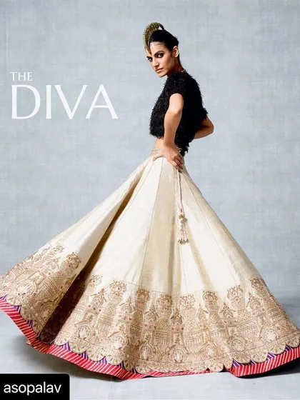 Styled for Asopalav's 'The Diva' campaign, this look features a pristine ivory and gold lehenga with a dramatic, feathered black top and a gold mohawk. This styling choice transforms a traditional bridal piece into a daring, high-fashion statement.
