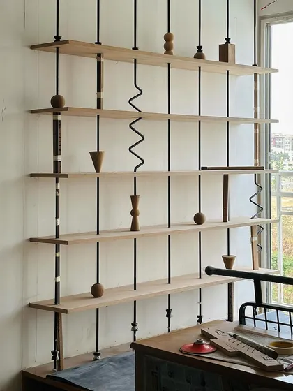 Rooms for kids should be fun and imaginative. This whimsical suspended bookshelf, with its playful wooden beads and squiggles, is a perfect example of how we bring creativity and joy into every corner of a home.