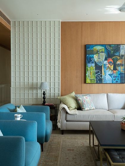 Here, the clean lines of the tactile wall paneling and the warmth of oak veneer create an idyllic backdrop. The space is brought to life with pops of blue, curated art, and a mix of textures for a feeling of sophisticated comfort.