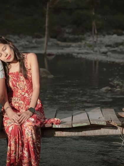 A peaceful and intimate moment from a riverside pre-wedding shoot, with the bride resting her head on the groom's shoulder.