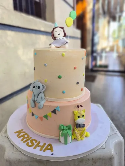 I love bringing imagination to life with cakes like this two-tiered birthday creation. It features adorable, hand-sculpted fondant animals like a baby elephant and giraffe, perfect for a whimsical celebration for your little one.