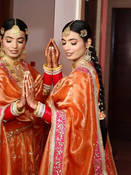 A moment of reflection for this beautiful Sikh bride. Her makeup is soft and luminous, perfectly complementing her vibrant orange and pink Anand Karaj outfit.