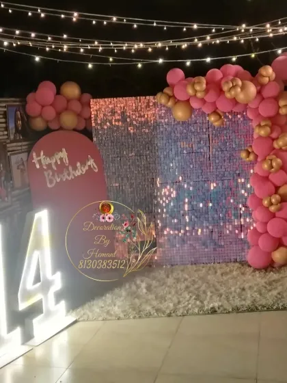 A glamorous setup for a 14th birthday party. This outdoor arrangement includes a pink sequin wall, a balloon arch, and large light-up marquee numbers, creating a perfect photo-op for a teenage celebration.