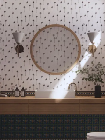 Inspired by the tropical setting of Goa, this powder room uses a playful palm tree wallpaper. The look is balanced with a clean wooden vanity and colorful patterned tiles, creating a fresh and fun space.