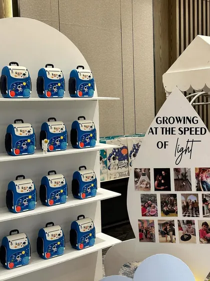 A creative gift station, with space-themed backpacks for the kids, and a photo display showing the birthday girl 'growing at the speed of light'.