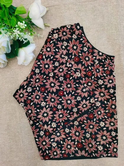 A black cotton boatneck blouse with a delicate floral print.