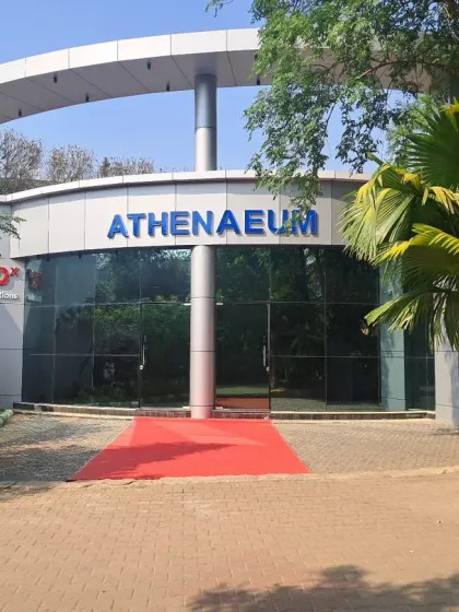 The entrance to the Athenaeum Cultural Centre at Krupanidhi, showcasing a modern design with a distinctive curved glass facade and a cantilevered roof structure. This project demonstrates our ability to create unique architectural forms for cultural and public spaces.