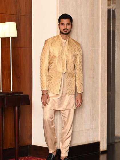A poised, full-length shot of a golden ethnic outfit, perfect for a lookbook or brand catalog.