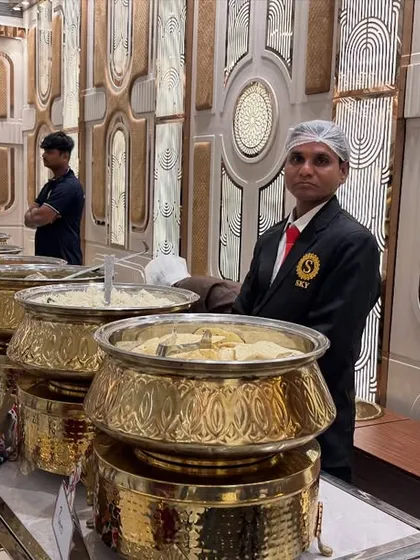 A professional setup is key to a great dining experience. Here is our elegant buffet line at Sky Banquet hall in Kharghar, with our uniformed staff ready to serve guests from beautiful golden chafing dishes.