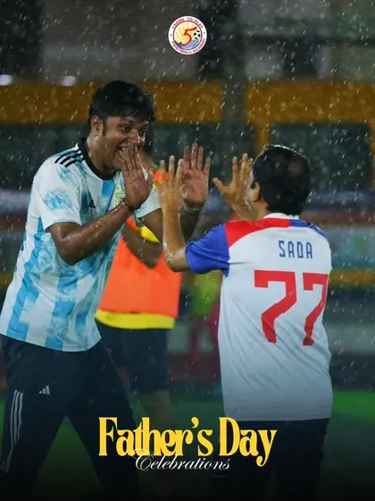 Two fathers sharing a high-five in the rain during our fun-filled Father's Day football event.