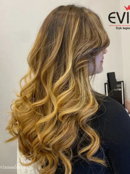 For clients with long hair, a golden blonde balayage can create a truly glamorous look. The curls at the end help to showcase the beautiful gradient from a darker root to bright ends.