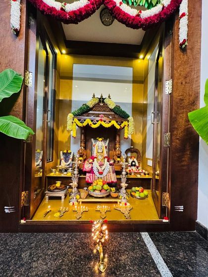A home pooja mandir beautifully lit for Diwali, with the Goddess dressed in one of our traditional silk sarees.