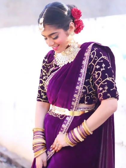 A graceful pose showing the details of the velvet saree and the gold kamarbandh.