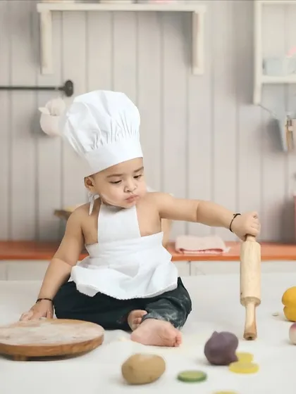 A little chef getting serious with his rolling pin. My themed shoots, like this kitchen setup, are designed with interactive props to bring out your child's personality.