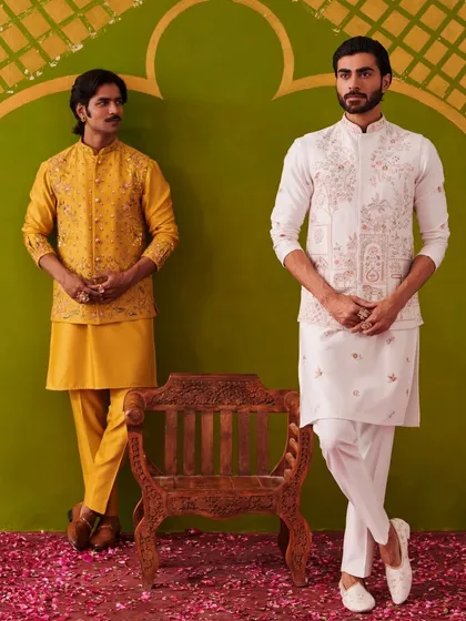 A vibrant yellow kurta set stands alongside an elegant white one. This image from the Nazaakat collection photoshoot highlights the collection's use of both bold and subtle color palettes.