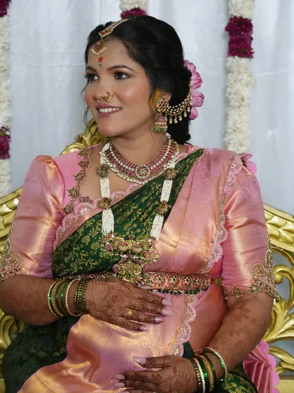 A seated portrait showing the intricate details of the jewelry, blouse, and makeup.