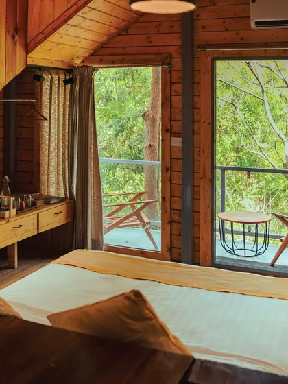 Welcome to your cozy, rustic cabin. With warm wooden interiors and a private balcony looking out into the forest, it's the perfect home base for your nature retreat.