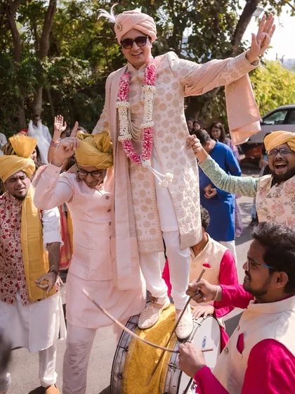Nothing matches the energy of a Baraat. This shot of the groom dancing on a dhol, surrounded by his cheering friends, perfectly captures the high-energy celebration and madness of an Indian wedding procession.