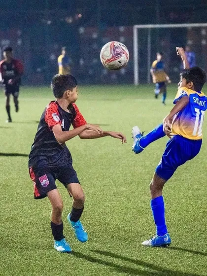 An aerial challenge between our player and an opponent during the U13 semi-final match.