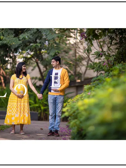 This couple's casual outfits and "LOVE" props make for a fun and relaxed maternity photo.