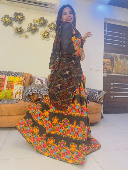 A twirling shot of the black floral embroidered lehenga, highlighting the beautiful flare and colorful details of the skirt.