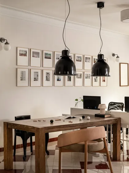 A look inside our own commercial studio in Mumbai, where we bring our ideas to life. This space features a large wooden collaboration table under dramatic black pendant lights, with a gallery wall of our inspirations. It’s designed to be a functional workspace that feels warm, human, and encourages creativity.