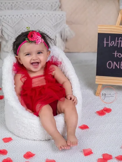 A huge, happy smile from her little armchair. The "Halfway to ONE" sign marks this special occasion perfectly.