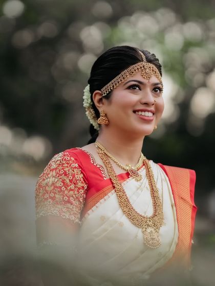 A close-up portrait that captures the bride's radiant smile. The makeup is soft and enhances her features, creating a timeless and elegant bridal look.