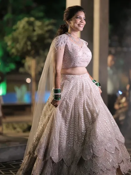 A full-length shot of the bride, her smile as bright as her beautiful lehenga.