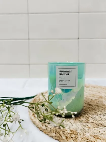 A styled shot of our Summer Sorbet jar candle. The green holographic finish catches the light, adding a cool vibe to any room.