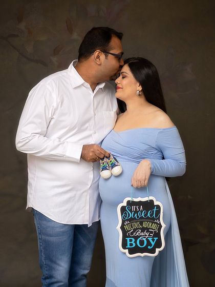 It's a boy! This couple chose to announce the gender with a chalkboard sign and adorable baby sneakers, making for a joyful and memorable portrait.