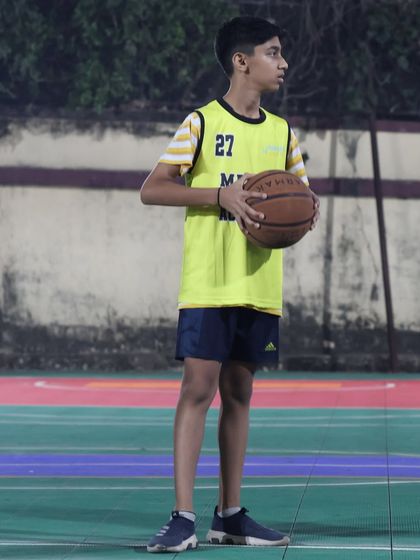 A player holds the ball in a triple-threat position, ready to shoot, pass, or dribble. We teach these fundamental situations to make our players versatile.