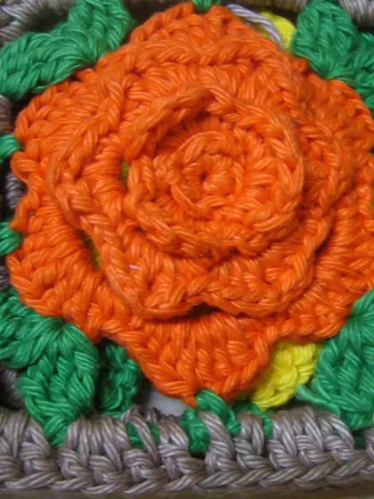 A close-up of one of the 3D rose granny squares. This technique adds a beautiful, sculptural element to the project.