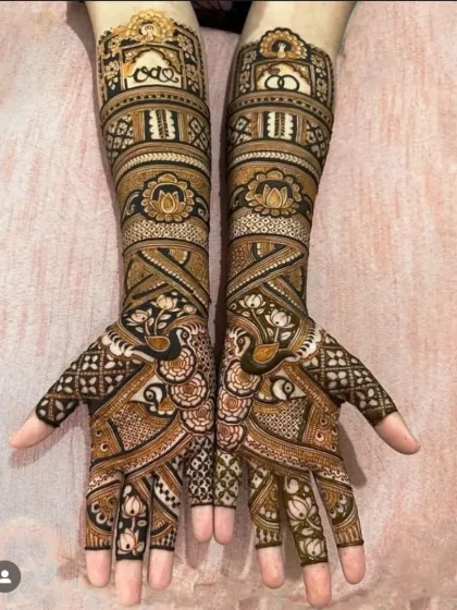 Symmetry and sharpness are obsessions for me. This full-arm bridal mehendi features perfectly mirrored peacocks and architectural jharokha patterns, showing the 'baariki' or fine detailing that I am known for.