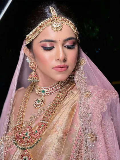 A close-up on the eye makeup, featuring a beautiful blend of pink and gold shimmer that makes her eyes sparkle.
