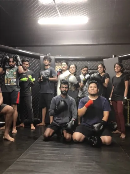 Caged but growing. The team posing inside the MMA cage after a tough session. This is where we sharpen our skills.