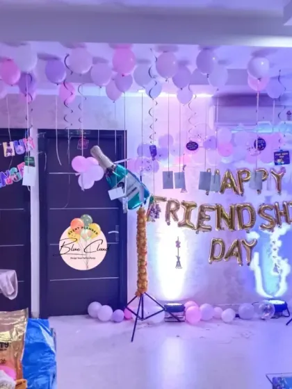 A fun 'Happy Friendship Day' party setup with foil letters, a neon sign, and balloons scattered around the room.