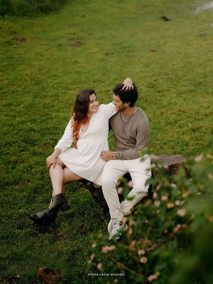 A relaxed moment of togetherness, sitting on a rock amidst the natural beauty of the landscape.